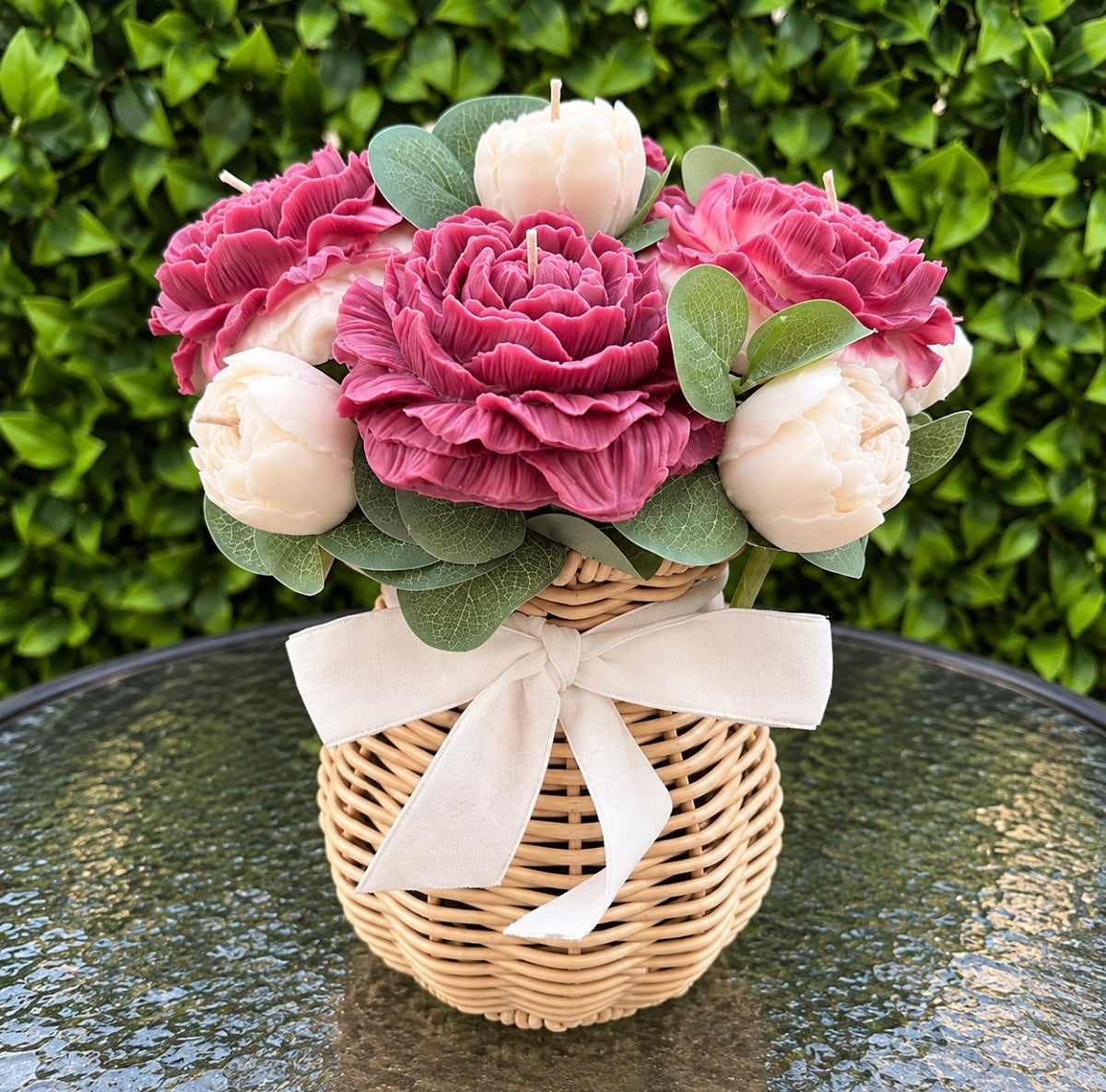 Pink wax peonies and roses in a wicker basket with white bow by Missy Sol