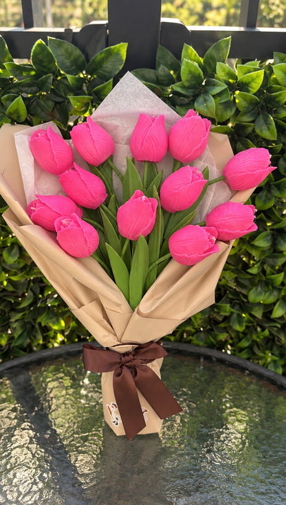 Wrapped bouquet of pink wax tulips with a brown ribbon by Missy Sol