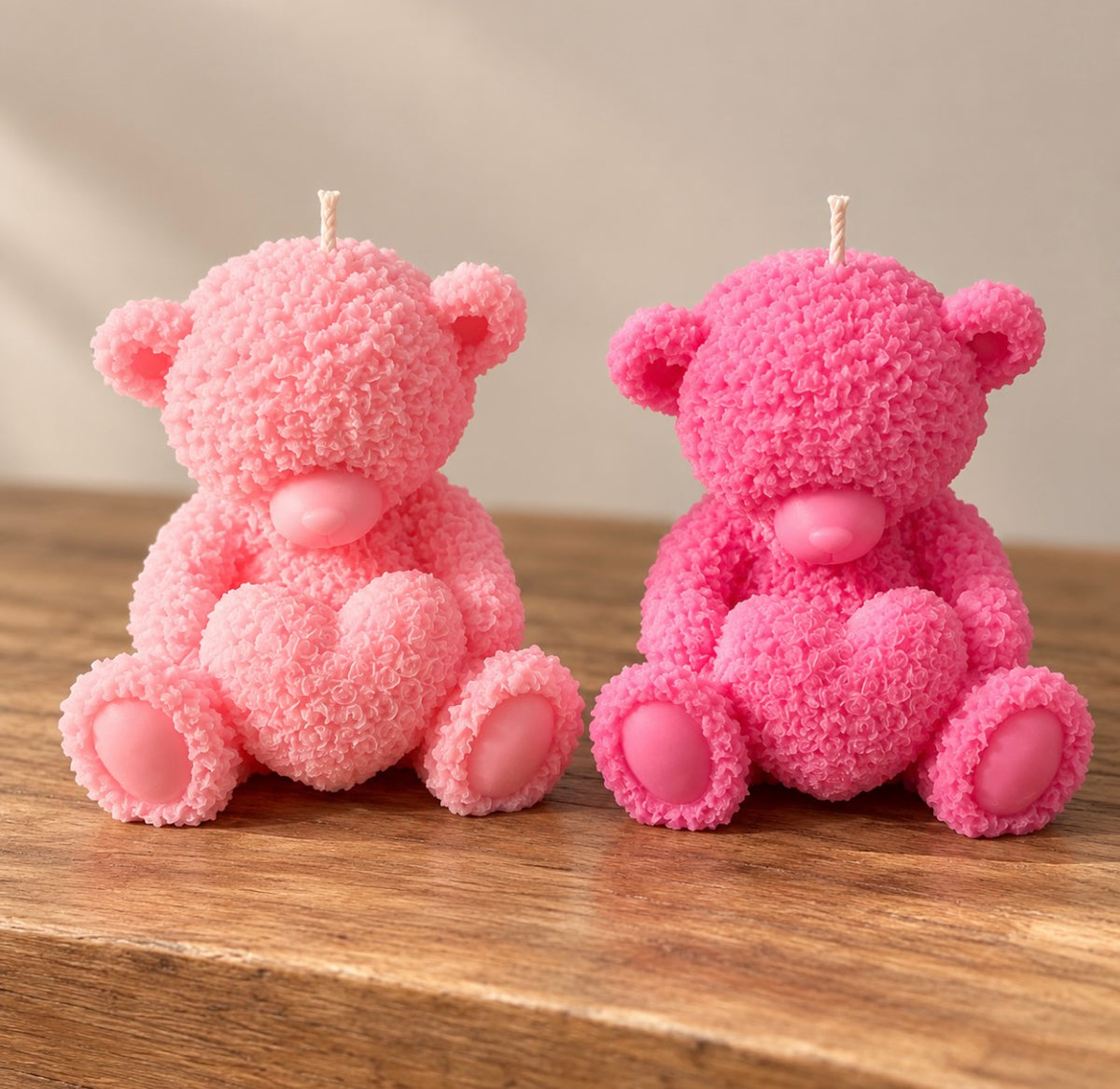 Two pink textured teddy bear candles holding hearts by Missy Sol