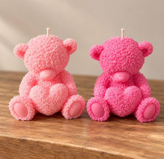 Two pink textured teddy bear candles holding hearts by Missy Sol